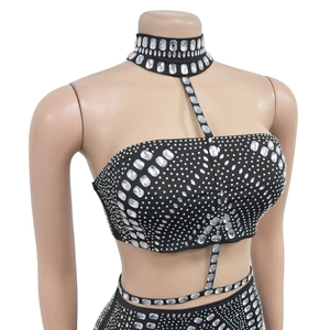 Détail d'un ensemble deux pièces noir orné de strass brillants sur tissu en maille