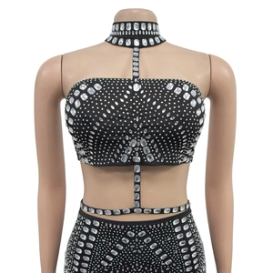Détail de strass blancs étincelants sur robe noire sans manches avec collier de cou