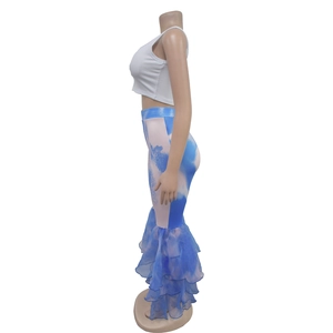 Détail du pantalon évasé avec imprimé tie-dye bleu et ourlet à volants en organza