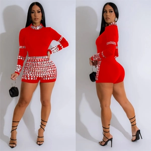 Detail of red rhinestone jumpsuit with sparkling crystals on semi-high neck and long sleeves