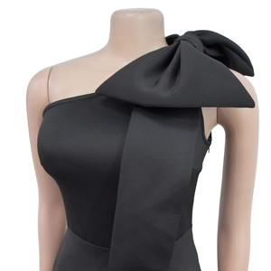 Detail eines schwarzen One-Shoulder-Kleides mit einer großen Schleife an der Schulter