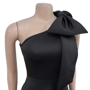 Detail eines schwarzen One-Shoulder-Kleides mit einer großen Schleife am Schultergurt