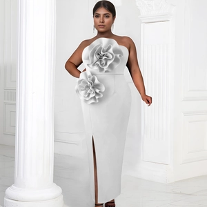 Detailed close-up of 3D floral decoration on white strapless evening dress with side slit