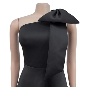 Detail eines schwarzen One-Shoulder-Kleids mit großer Schleife an der linken Schulter
