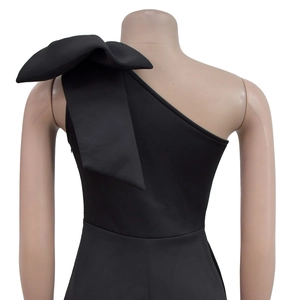 Detail eines schwarzen One-Shoulder-Kleides mit großer dekorativer Schleife an der Schulter