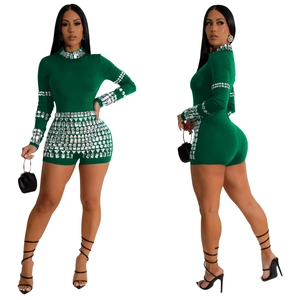 Detail of dark green romper with sparkling rhinestones on the sleeves and neckline