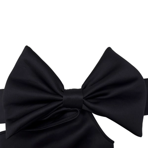 Detail aus elegantem schwarzem Satinstoff mit großer dekorativer Schleife und sanftem Glanz