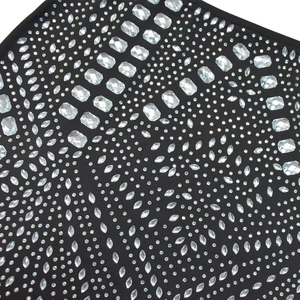 Gros plan détaillé des strass étincelants sur le tissu noir élastique de la robe