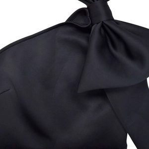 Detail eines eleganten schwarzen One-Shoulder-Abendkleides mit einer großen Satinschleife