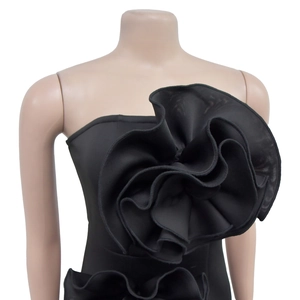 Detailed view of the 3D floral accent and fabric texture on a black strapless dress