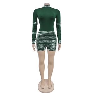 Detail of dark green rhinestone jumpsuit featuring high collar and long sleeves for parties