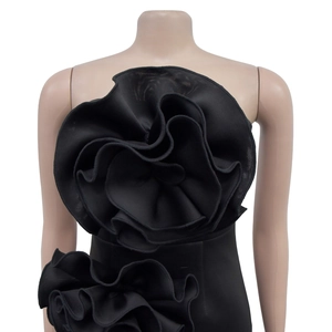 Detail of elegant black strapless dress with large 3D floral ruffles and slim fit design