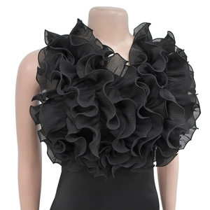 Dettaglio di balze in chiffon nero a più strati su un elegante abito lungo con scollo a V