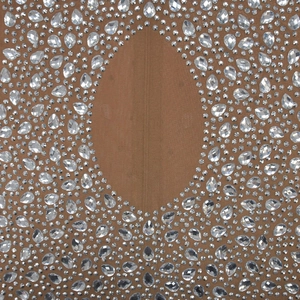 Detail of brown mesh fabric with sparkling rhinestones in round and teardrop shapes