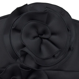 Detailed close-up of a 3D fabric flower on a black sleeveless dress with tiered petals