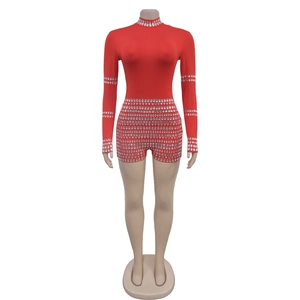 Detail showing shimmering silver rhinestones on the cuffs of a red long sleeve bodysuit