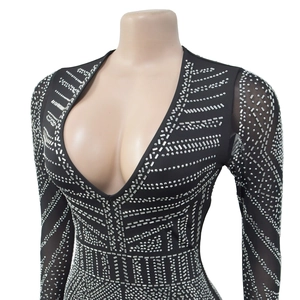 Détail de la robe en maille noire avec strass argentés et décolleté en V plongeant