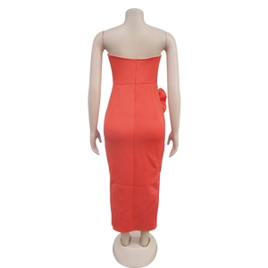 Detail view of the back zipper closure on a coral red strapless maxi dress with side slits