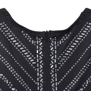Détails des strass en V et de la fermeture éclair invisible sur la robe noire