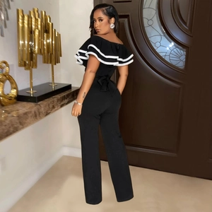 Detail of elegant black jumpsuit with white double-layer ruffle neckline and bow on back