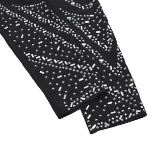 Détails de strass argentés aux motifs ondulés sur tissu en maille noire transparente