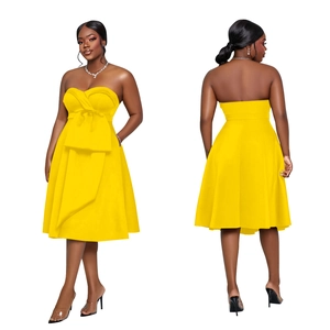 Detail of elegant yellow strapless A-line midi dress featuring a large bow on the bodice