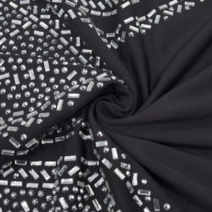 Gros plan du tissu de robe élastique noir avec motifs géométriques en strass