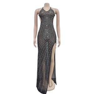 Détail d'une robe de soirée noire en tulle avec strass argentés et fente latérale haute