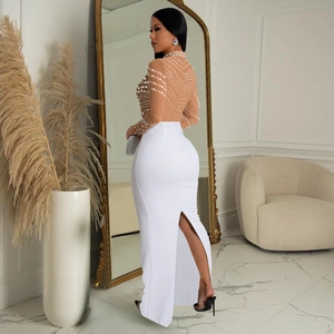 Detail of elegant white high-waist skirt featuring a slit and beaded mesh top