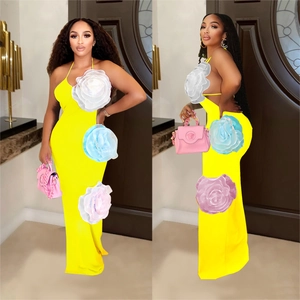 Detailed view of yellow halter neck maxi dress featuring large 3D floral decorations