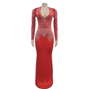 Détail d'une robe rouge longue avec des strass argentés et un décolleté en V profond