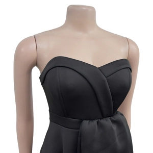 Detail showing the elegant sweetheart neckline and ruched bodice of a black midi dress