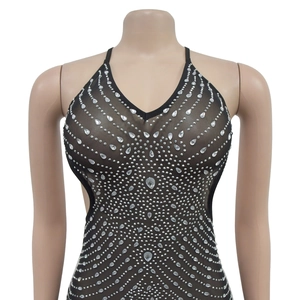 Détail du tissu en maille noire avec strass argentés brillants et décolleté en V