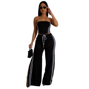 Détail du haut bandeau noir et du pantalon large avec bandes blanches de sport chic