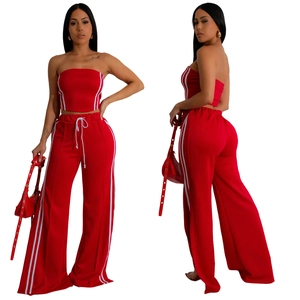 Détail du haut sans manches rouge et du pantalon large avec bandes latérales blanches