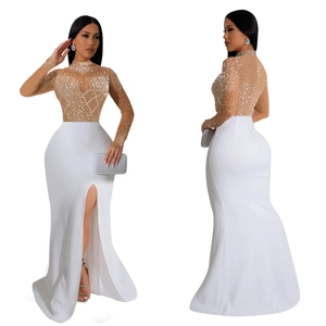 Detail of elegant white slit evening dress with sheer sequined mesh and rhinestones