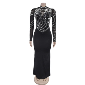 Detailed close-up of white pearls and rhinestones on black sheer mesh evening dress