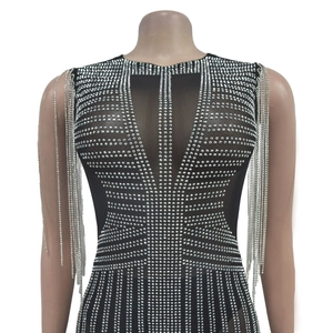 Detail of black mesh bodysuit with silver rhinestones and long chain tassels on shoulders
