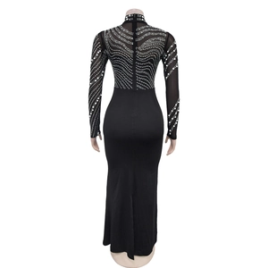 Detail view of the back zipper and white pearl wave patterns on a black sheer mesh dress