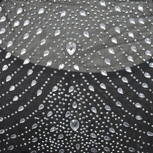Vue macro détaillée de strass étincelants sur un tissu en mesh noir pour robes élégantes