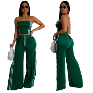 Détail du haut sans manches vert et du pantalon large avec bandes latérales