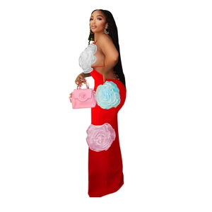 Detail view of a sleek red slim-fit maxi dress featuring a chic backless spaghetti strap design