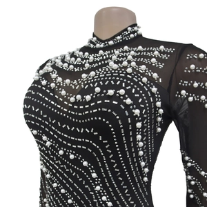 Detail of elegant black mesh dress with shimmering rhinestones and white pearls embroidery