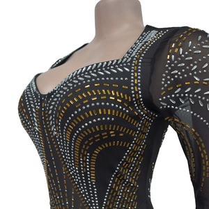Detail of slim fit black dress with sheer mesh sleeves and sparkling rhinestones
