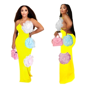 Detail of vivid yellow halter maxi dress featuring three 3D floral accents on the side
