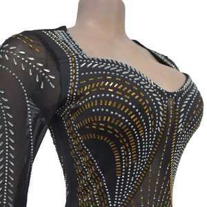 Detailed close-up of sparkling rhinestones and sequins on black long-sleeved mesh dress