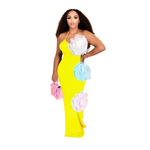 Detail of yellow halter maxi dress featuring 3D floral accents and elegant slim fit