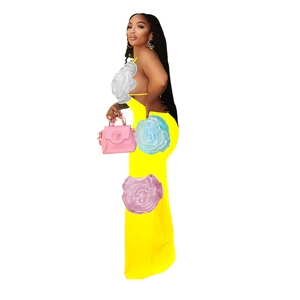 Detail view of yellow halter maxi dress featuring three large 3D floral appliques