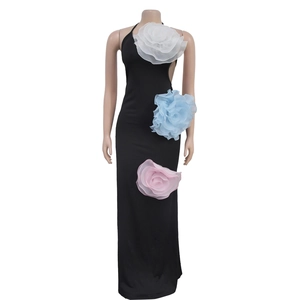Detail of 3D floral accents on a black halter maxi dress with cutout side waist