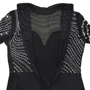 Close-up of black dress with intricate sequin, beadwork, and sheer mesh details
